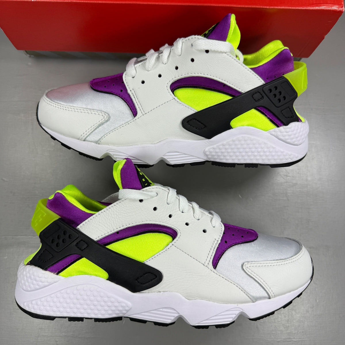 Nike white trainers with magenta neon accents and signature logo details.