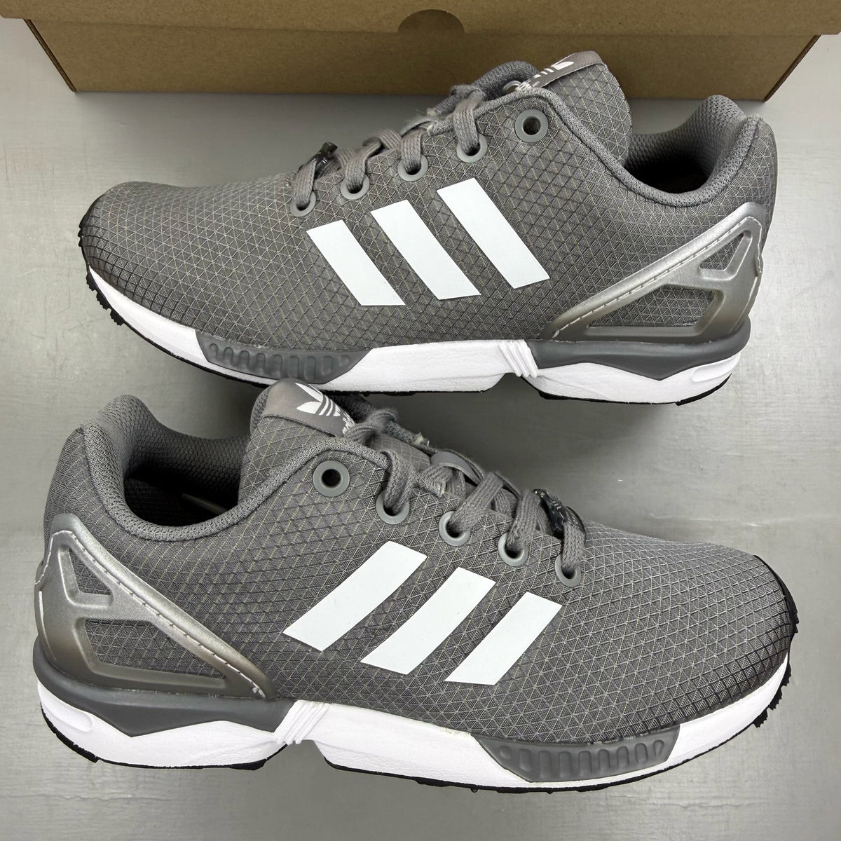 Adidas grey ZX Flux trainers with white accents and logo detail.