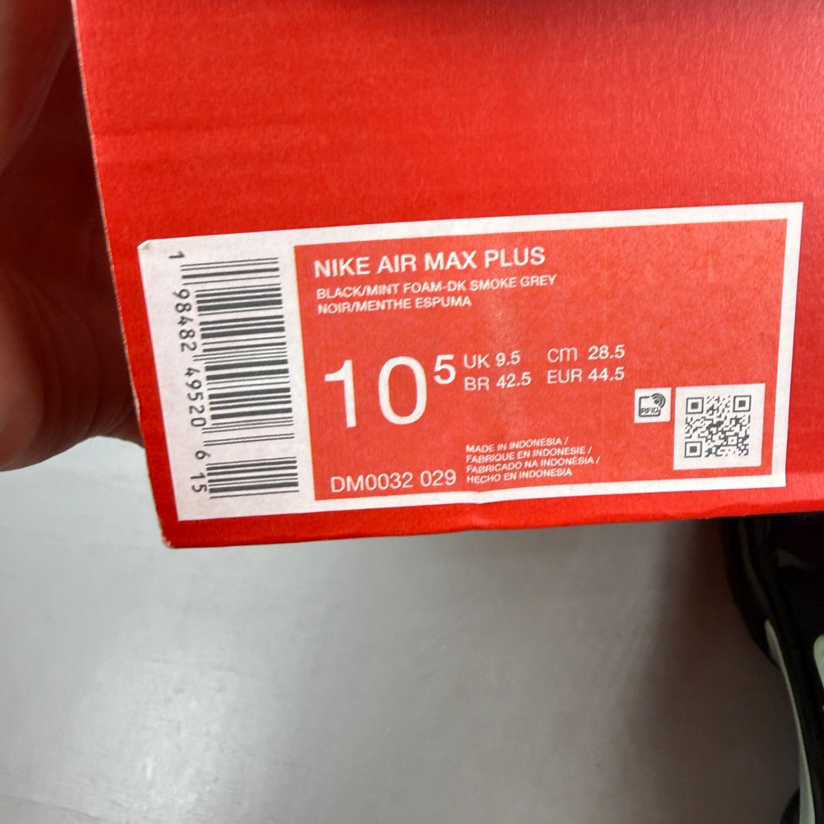 Nike Air Max Plus TN black trainers with mint green accents and signature logo.