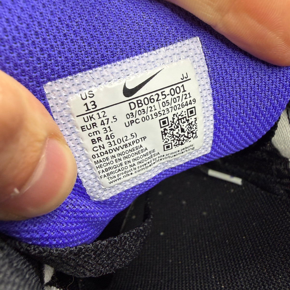 Nike Air Max 90 black trainers with purple accents and white sole, iconic design.