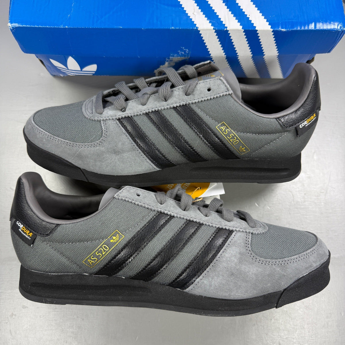 Adidas grey skate shoes with black accents and logo detail on tongue.