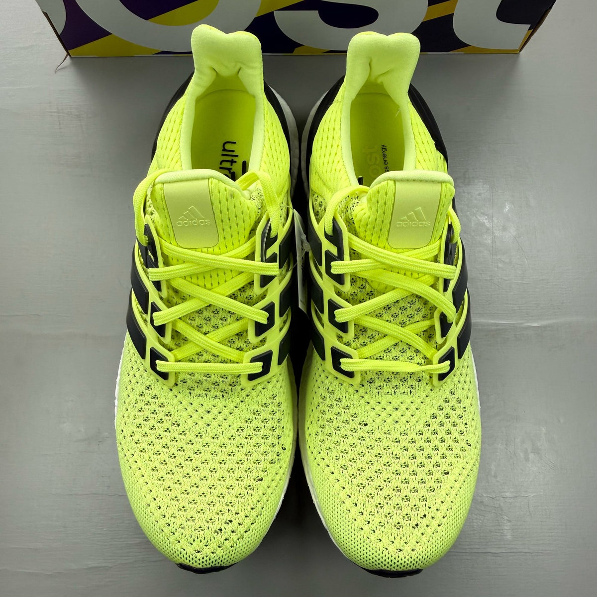 Adidas UltraBoost 1.0 yellow trainers with black and white accents, mesh upper.