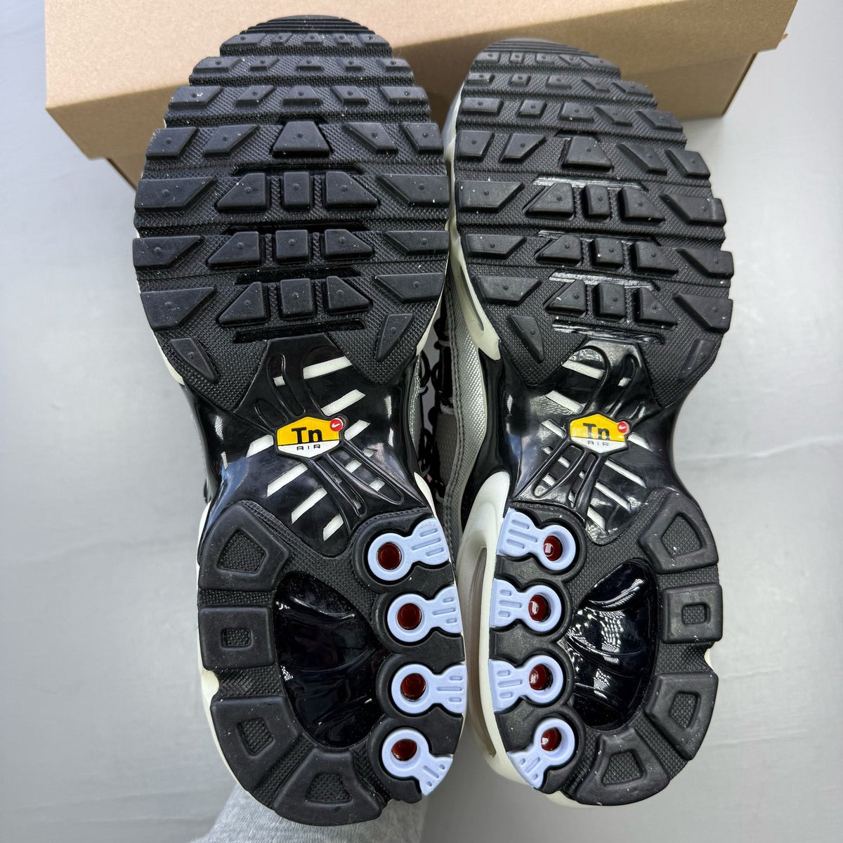 Nike black trainers with silver accents and toggle lacing system.