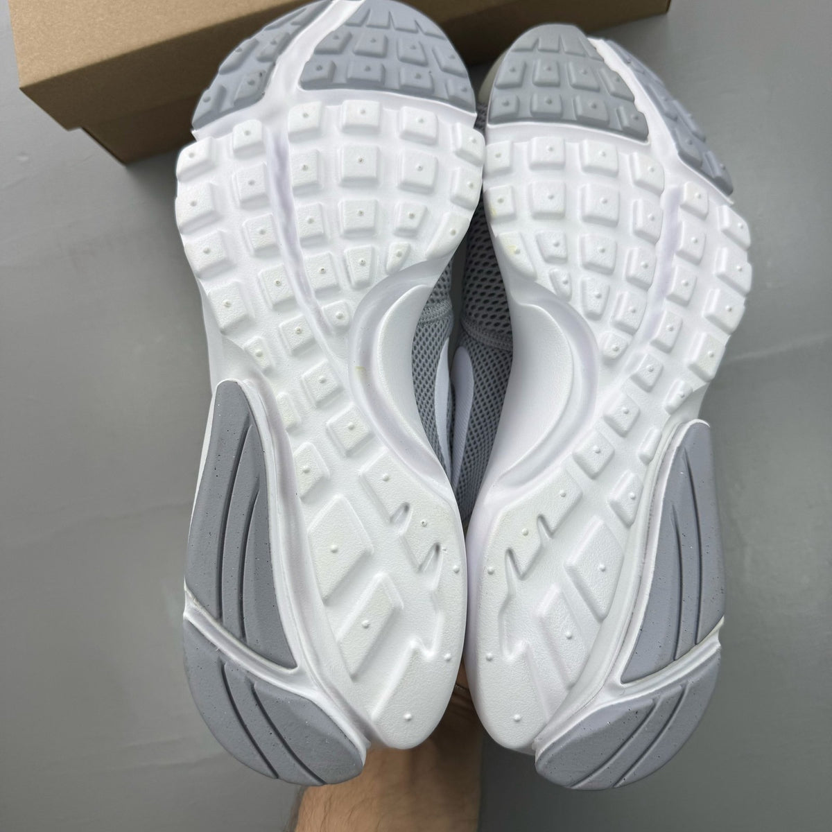 Nike Presto Fly grey trainers with white accents and logo detail.