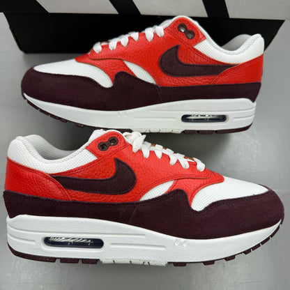 Nike Air Max 1 red trainers with white accents and logo detailing.