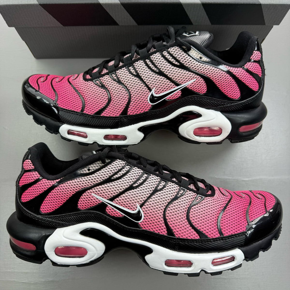 Nike Air Max Plus TN pink trainers with sunset gradient and signature swoosh logo.