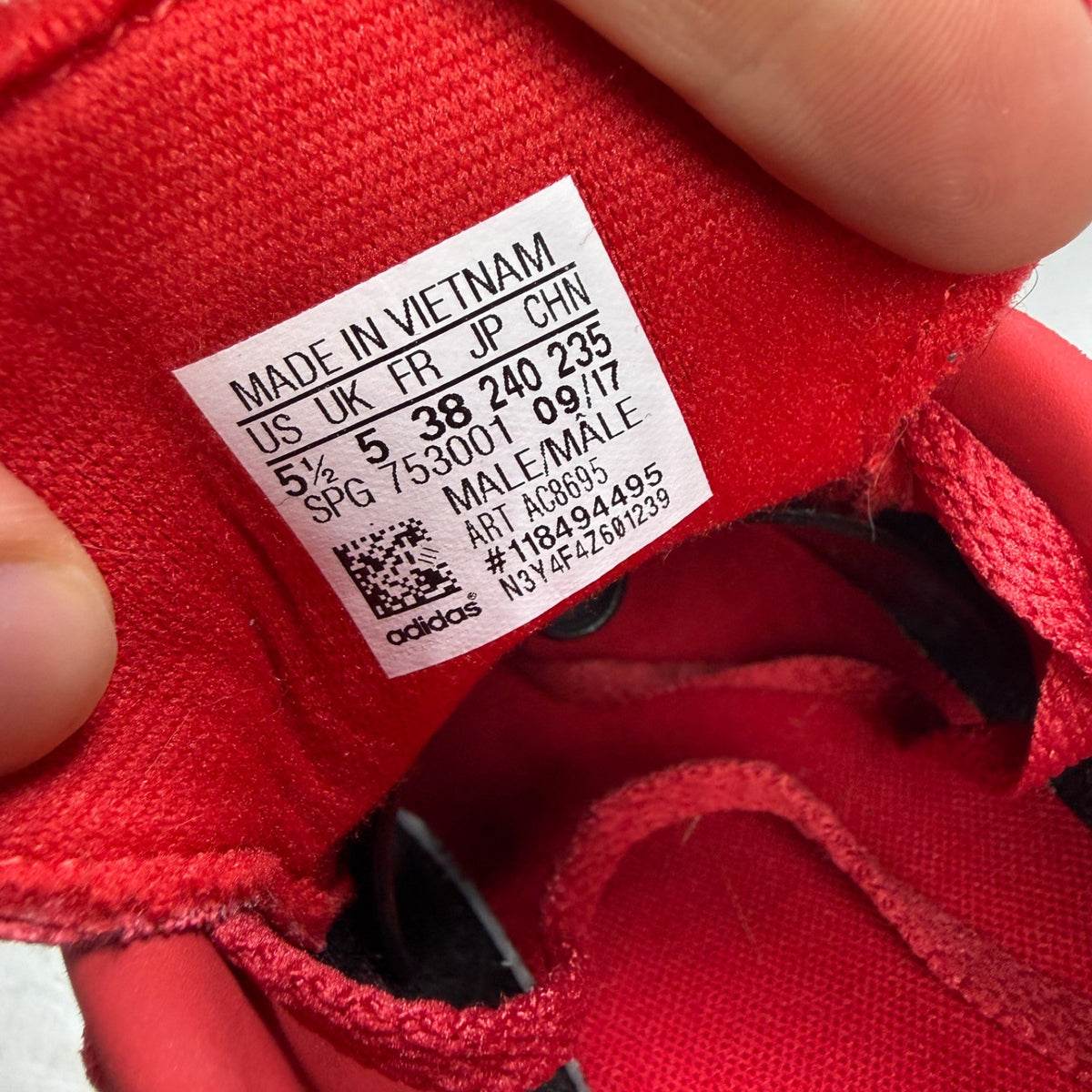 Adidas red suede running trainers with white logo and classic design details.