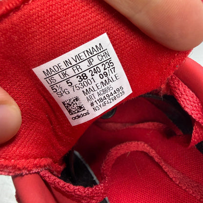 Adidas red suede running trainers with white logo and classic design details.
