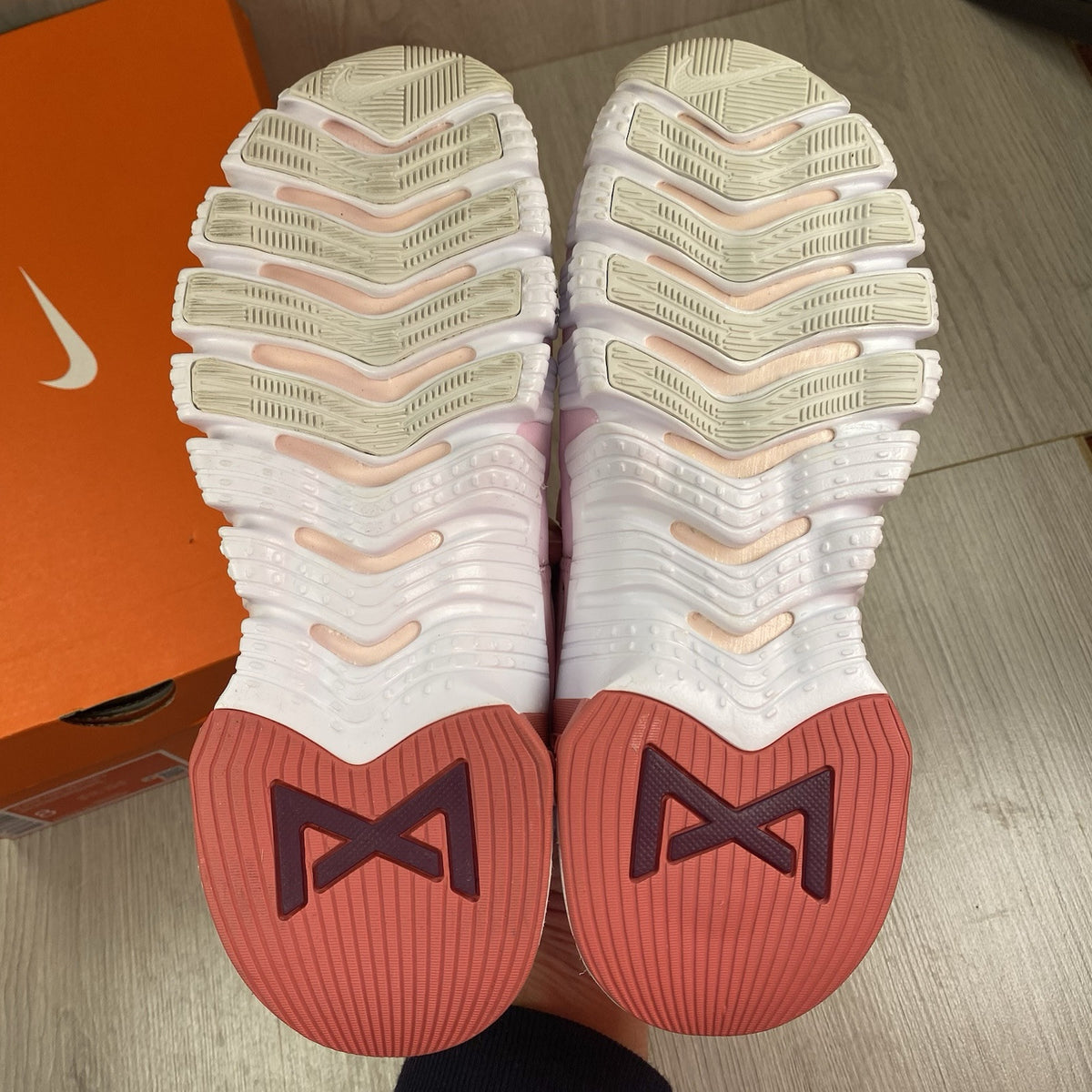 Nike Free Metcon 5 pink foam trainers with white accents and logo detailing.
