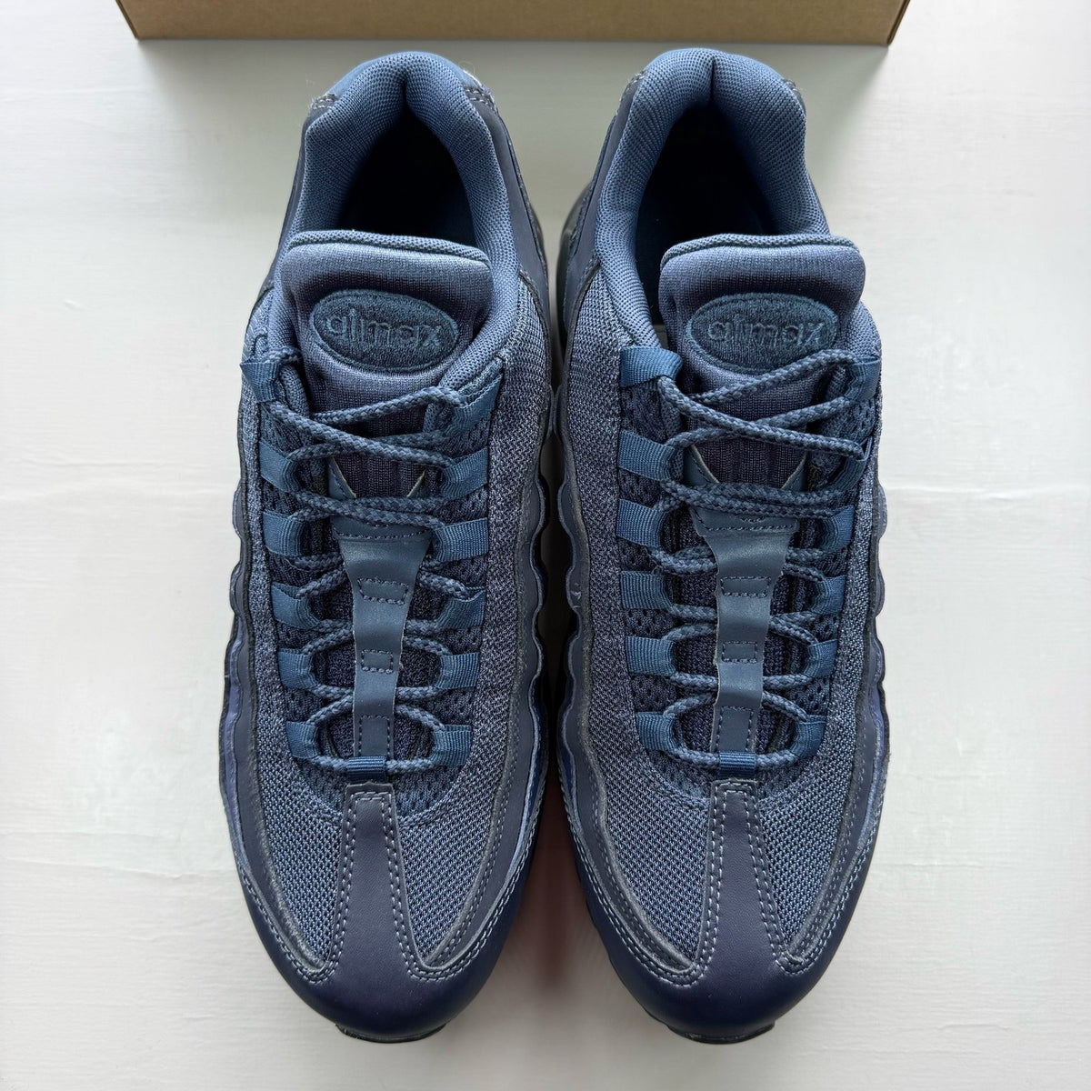 Nike Air Max 95 blue trainers with midnight navy accents and signature logo details.