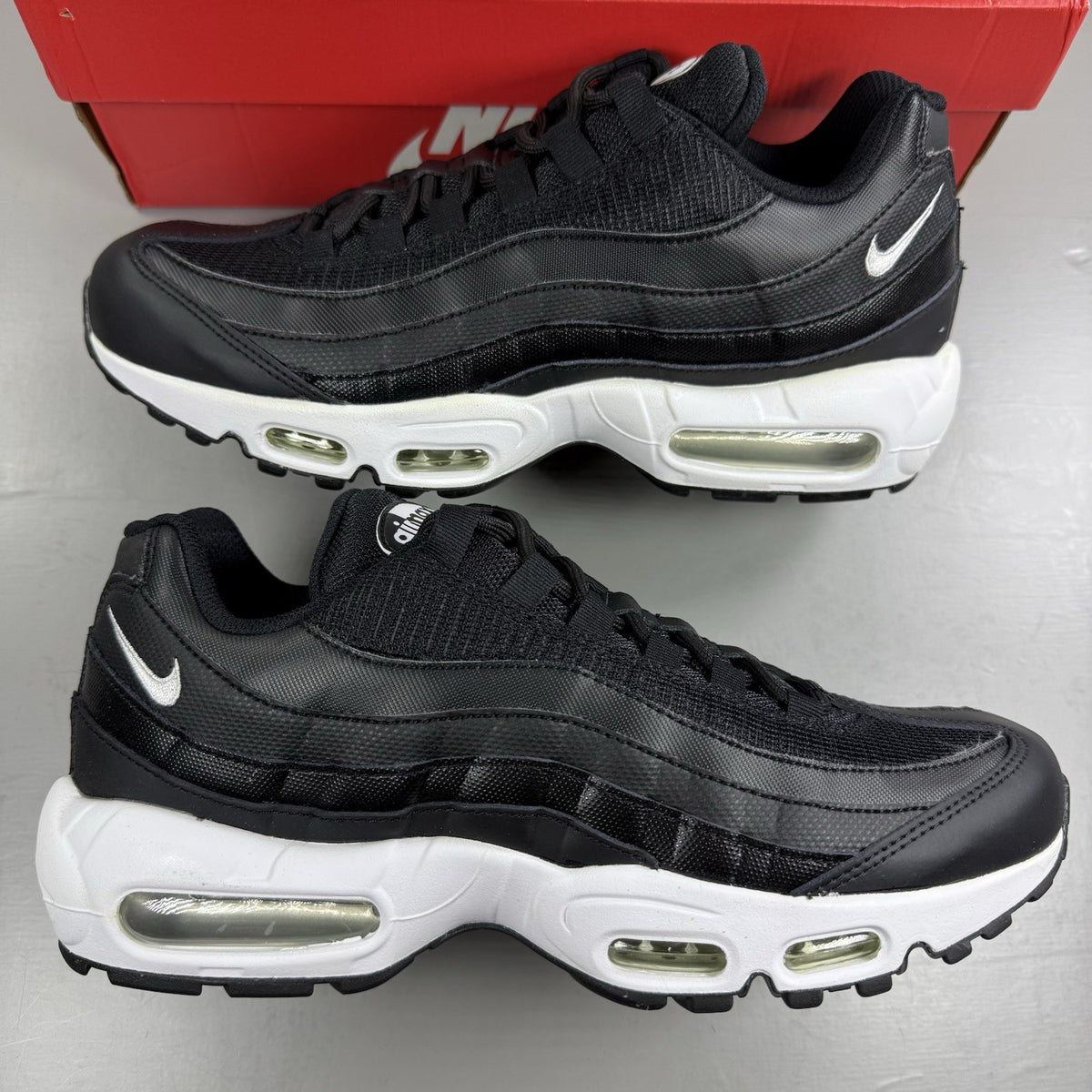 Nike Air Max 95 Essential black trainers with white accents and signature logo details.
