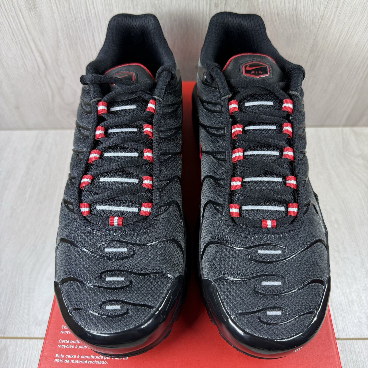 Nike TN Air Max Plus trainers black with red gradient and signature logo design.