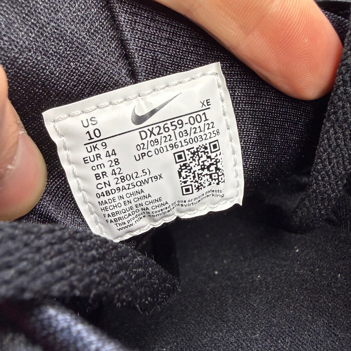Nike black athletic shoes with safety orange accents and grey detailing.