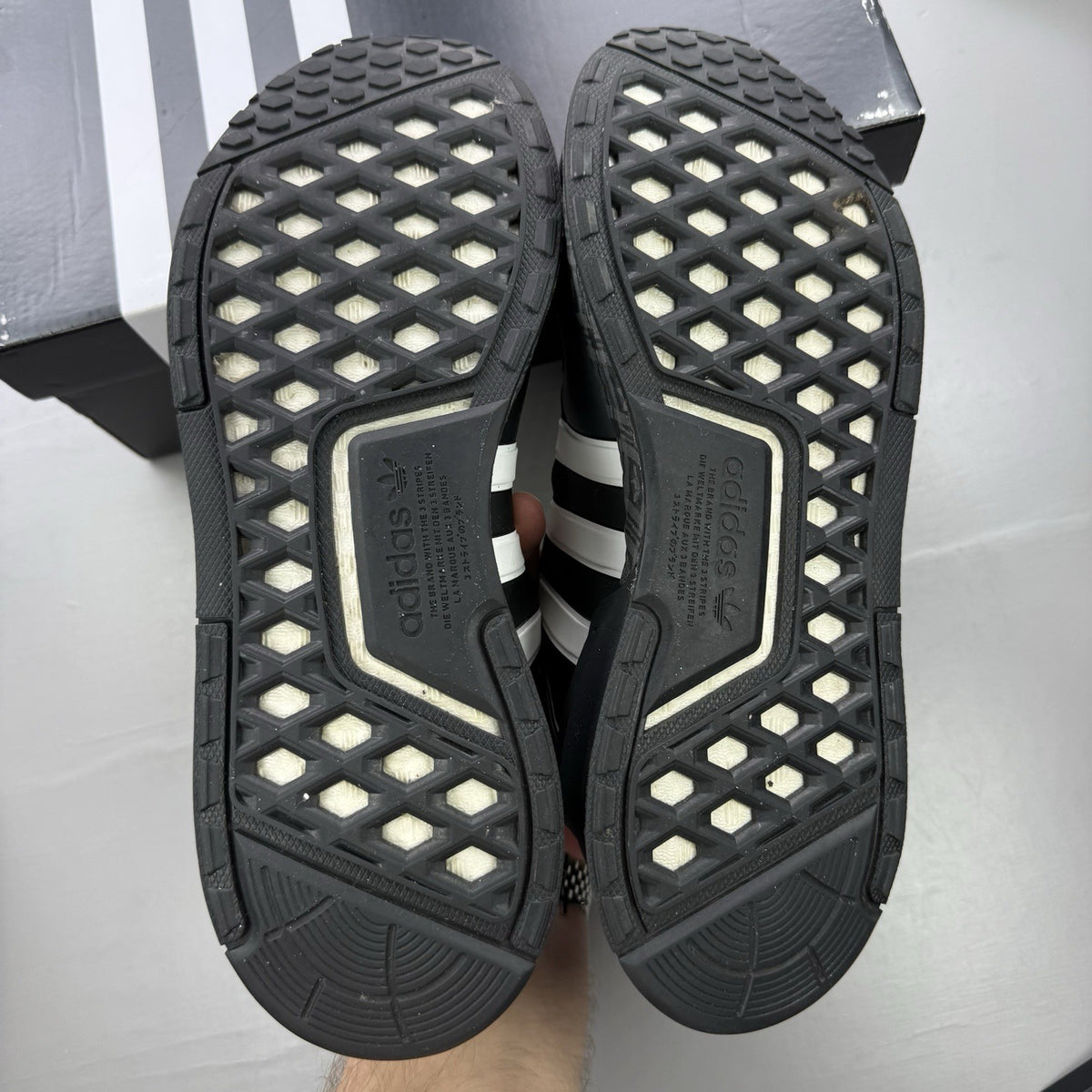 Adidas black trainers with white and gold accents, featuring a sleek design and logo.