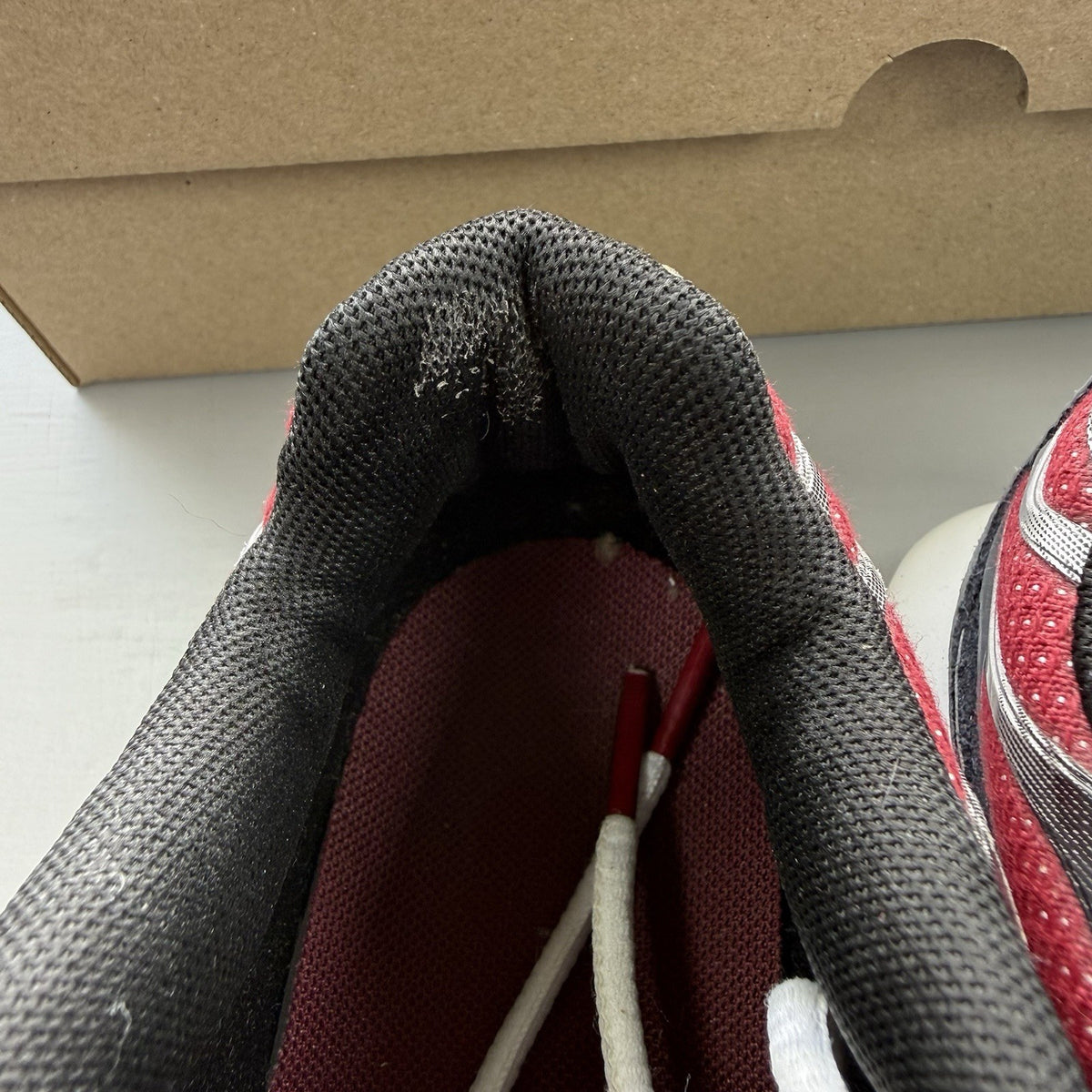 Nike Air Max Plus TN white trainers with red and black accents, featuring logo detailing.