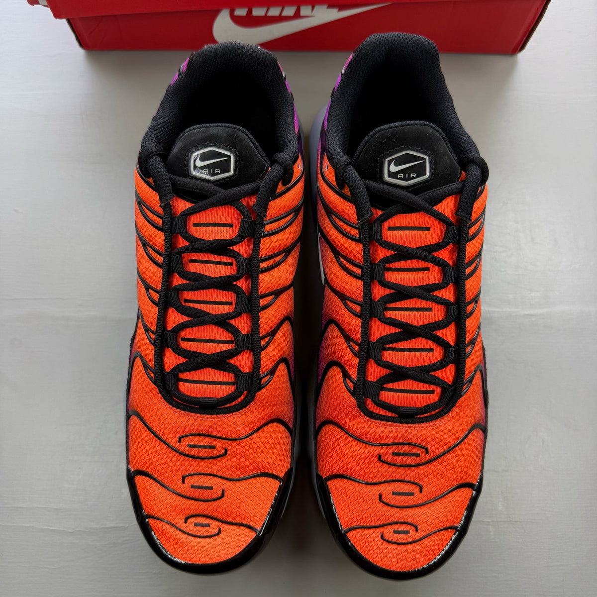 Nike Air Max Plus TN orange trainers with distinctive wave pattern and logo.