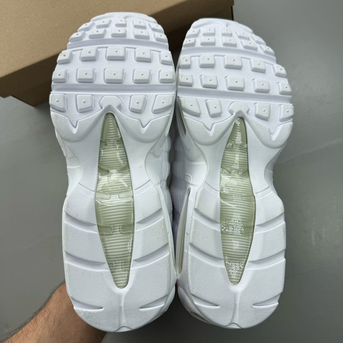 Nike Air Max 95 white trainers with mesh and leather upper, reflective accents.