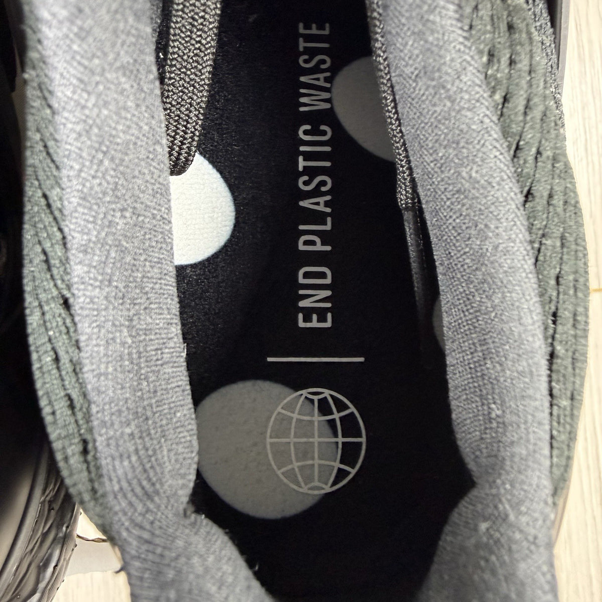 Adidas black trainers with white polka dot pattern and iconic three-stripe logo.