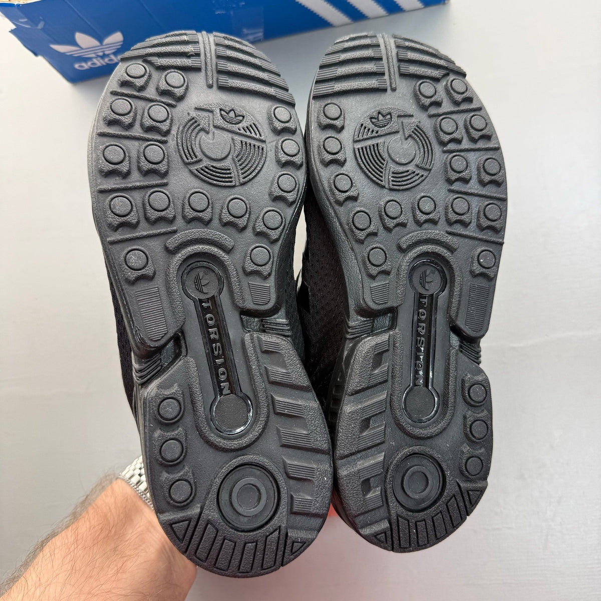 Adidas black trainers with sleek design and logo detail, perfect for kids.
