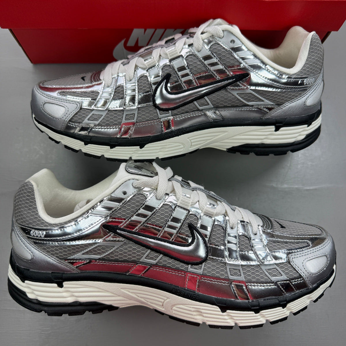 Nike deck shoes metallic silver with black and white accents, featuring logo details.