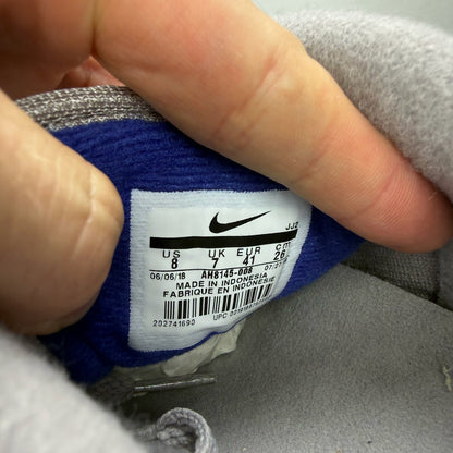 Nike Air Max 1 grey trainers with royal blue accents and signature logo.