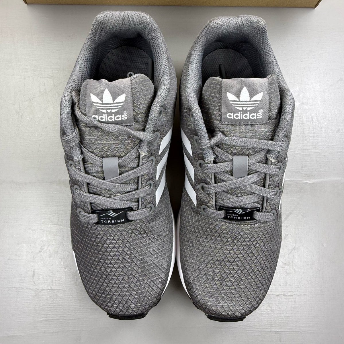Adidas grey ZX Flux trainers with white accents and logo detail.