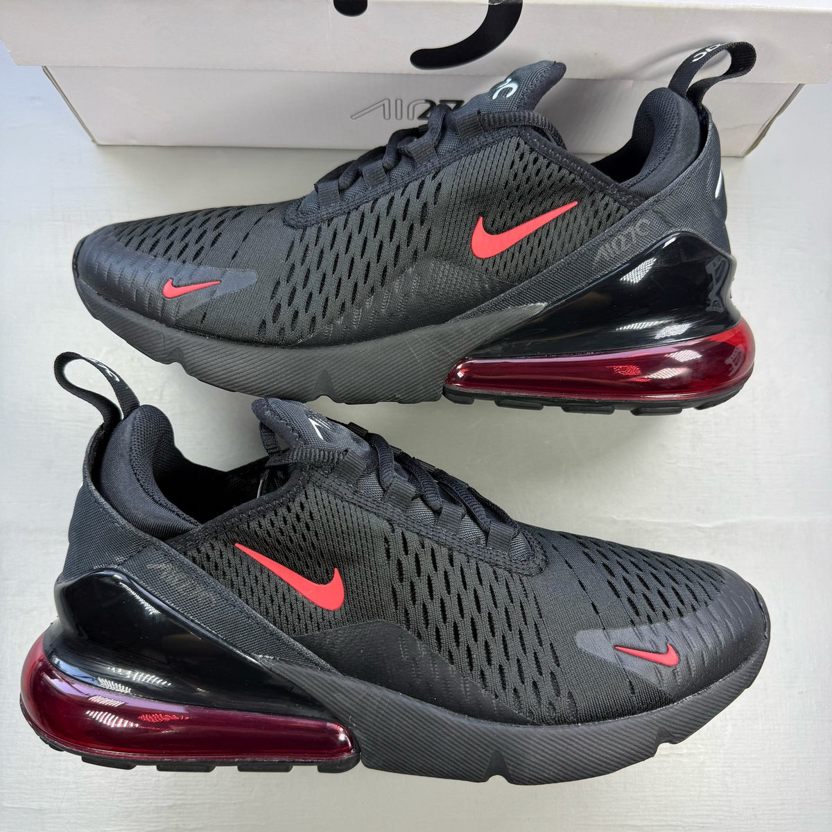 Nike Air Max 270 black trainers with university red accents and white sole.