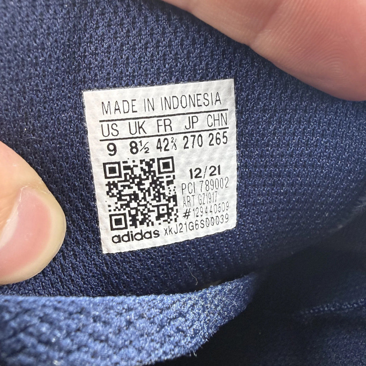 Adidas blue LA Trainer sneakers with white stripes and logo detailing.