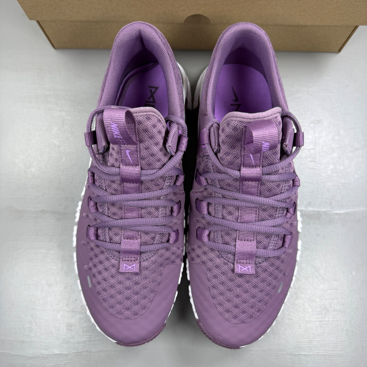 Nike Free Metcon 5 purple trainers with mesh upper and logo detail.