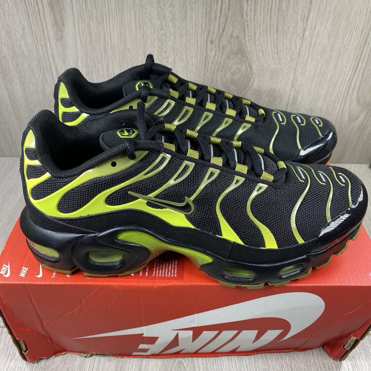 Nike Air Max Plus TN trainers black with cyber accents and mesh upper detailing.
