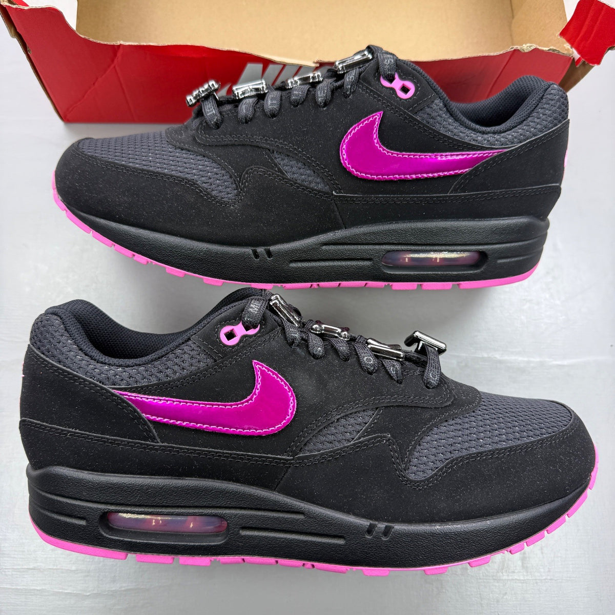 Nike trainers black with playful pink accents and Air Max cushioning.