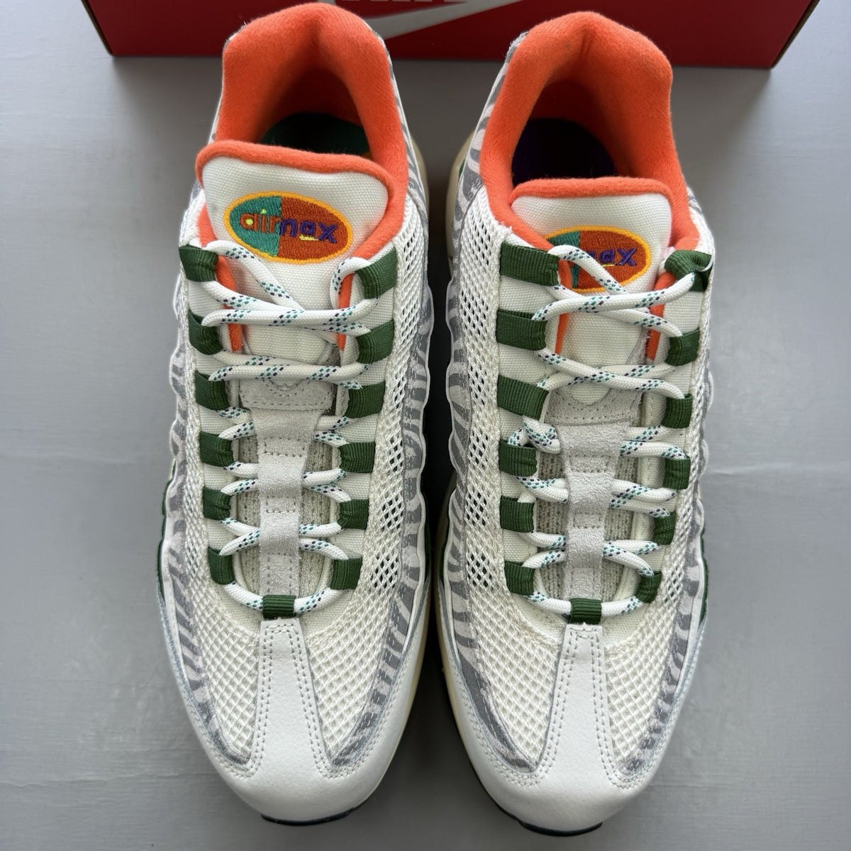 Nike Air Max 95 trainers white with safari green accents and textured material.