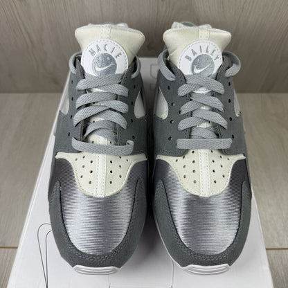Nike white trainers with grey accents and signature logo on the tongue.