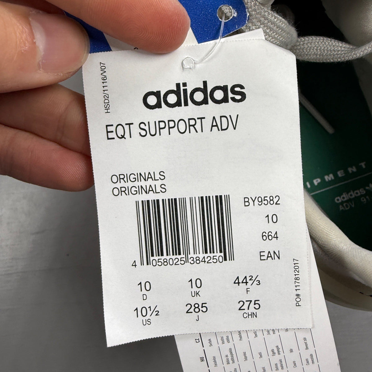 Adidas grey athletic shoes with mesh upper and signature three stripes logo.