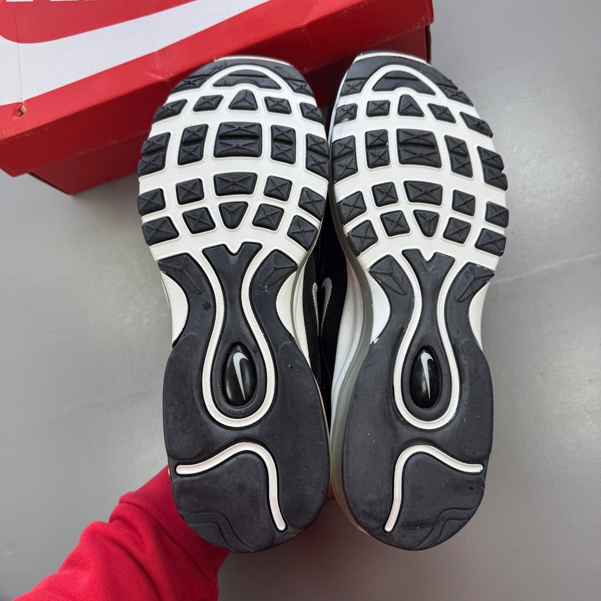 Nike black athletic shoes with metallic silver accents and signature logo detailing.
