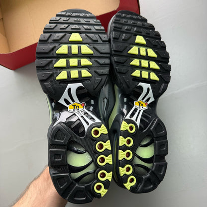 Nike Air Max Plus TN grey trainers with white and liquid lime accents, featuring logo details.