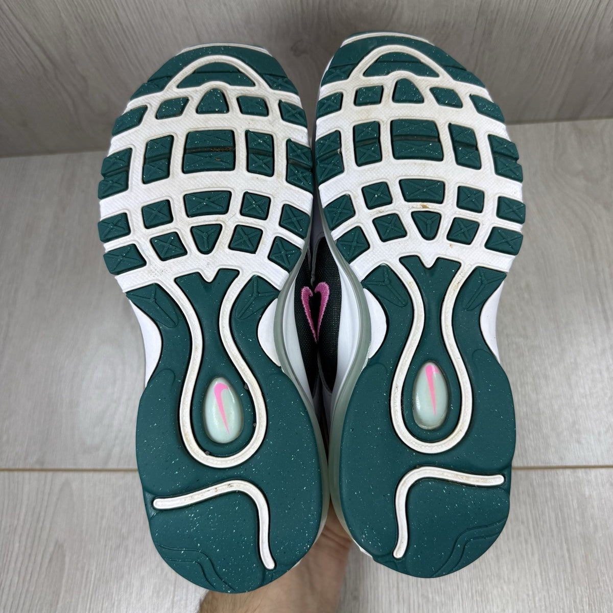 Nike Air Max 97 white trainers with teal accents and reflective detailing.