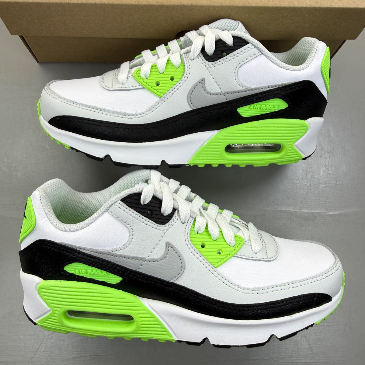 Nike Air Max 90 white trainers with black and lime blast accents, logo on tongue.