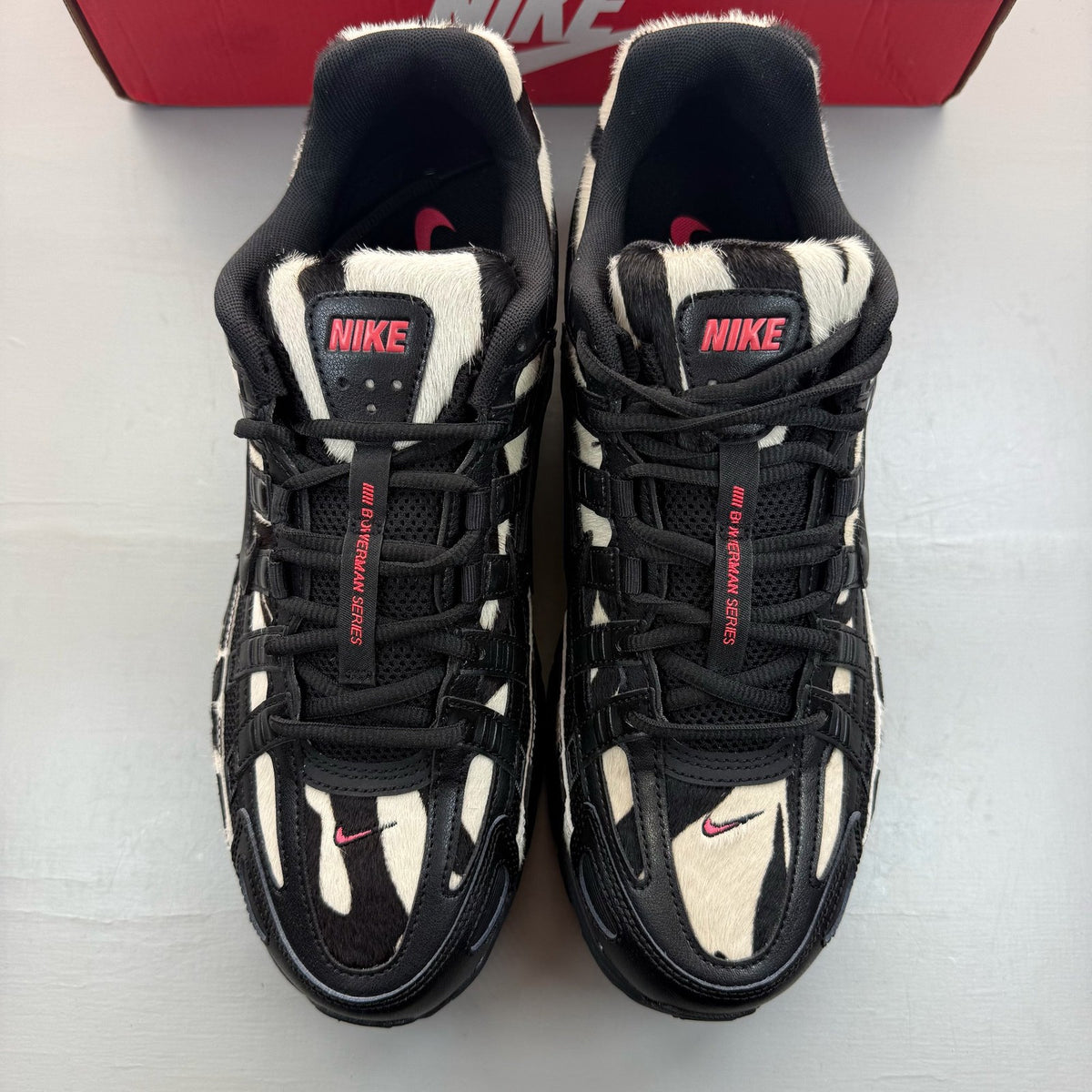 Nike black trainers with zebra pattern, solar red accents, and white detailing.