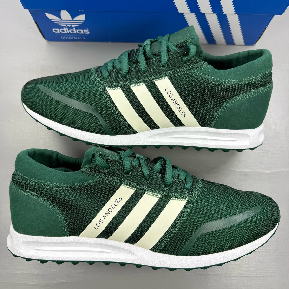 Adidas green trainers with white accents and logo detailing, brand new in box.