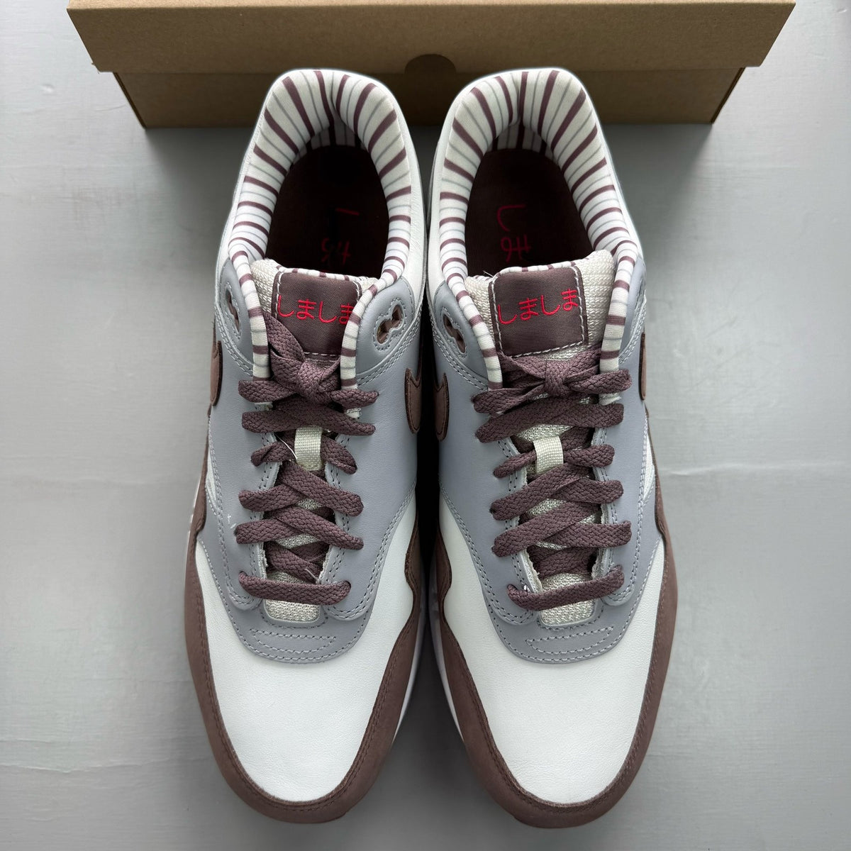Nike Air Max 1 brown trainers with premium Shima Shima pattern and logo details.