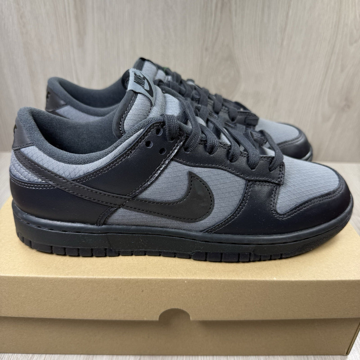 Nike Dunk Low Retro Off Noir grey trainers with black accents and signature swoosh logo.