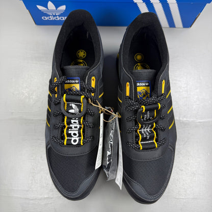 Adidas black deck shoes with gold accents and classic three-stripe logo.