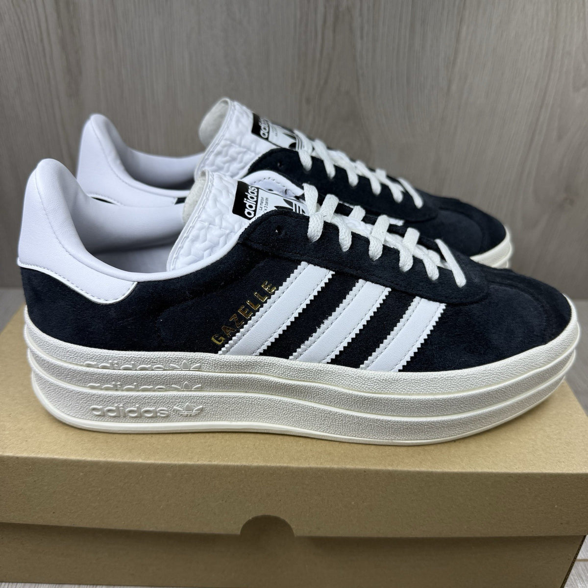Adidas Gazelle Bold black trainers with white stripes and logo detailing.