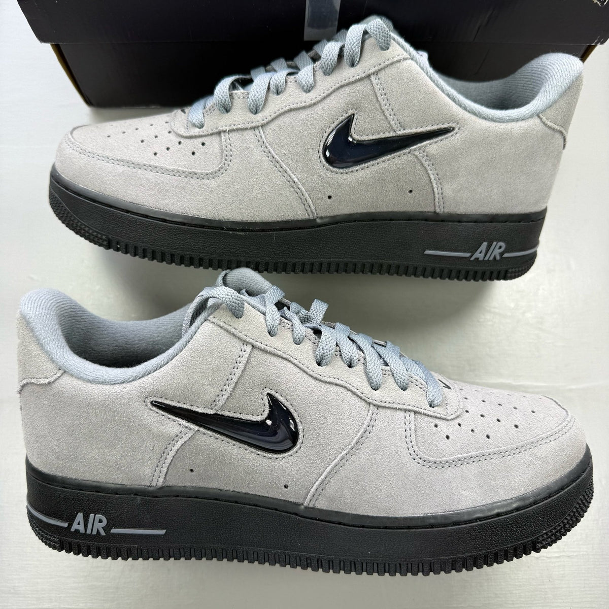 Nike Air Force 1 grey trainers with black accents and jewel logo detail.