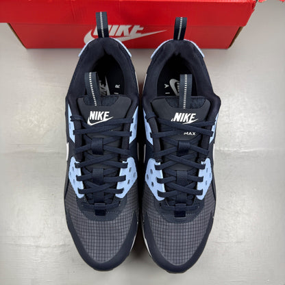 Nike Air Max 90 blue trainers with dark obsidian accents and signature swoosh logo.
