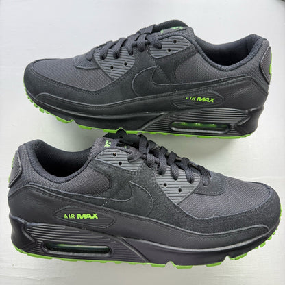 Nike Air Max 90 black trainers with green accents and logo detail on the tongue.