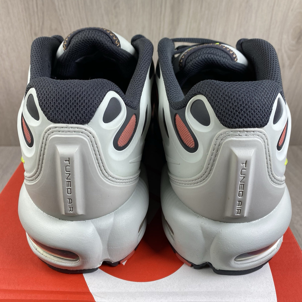 Nike Air Max Plus TN trainers silver with volt accents and signature logo details.