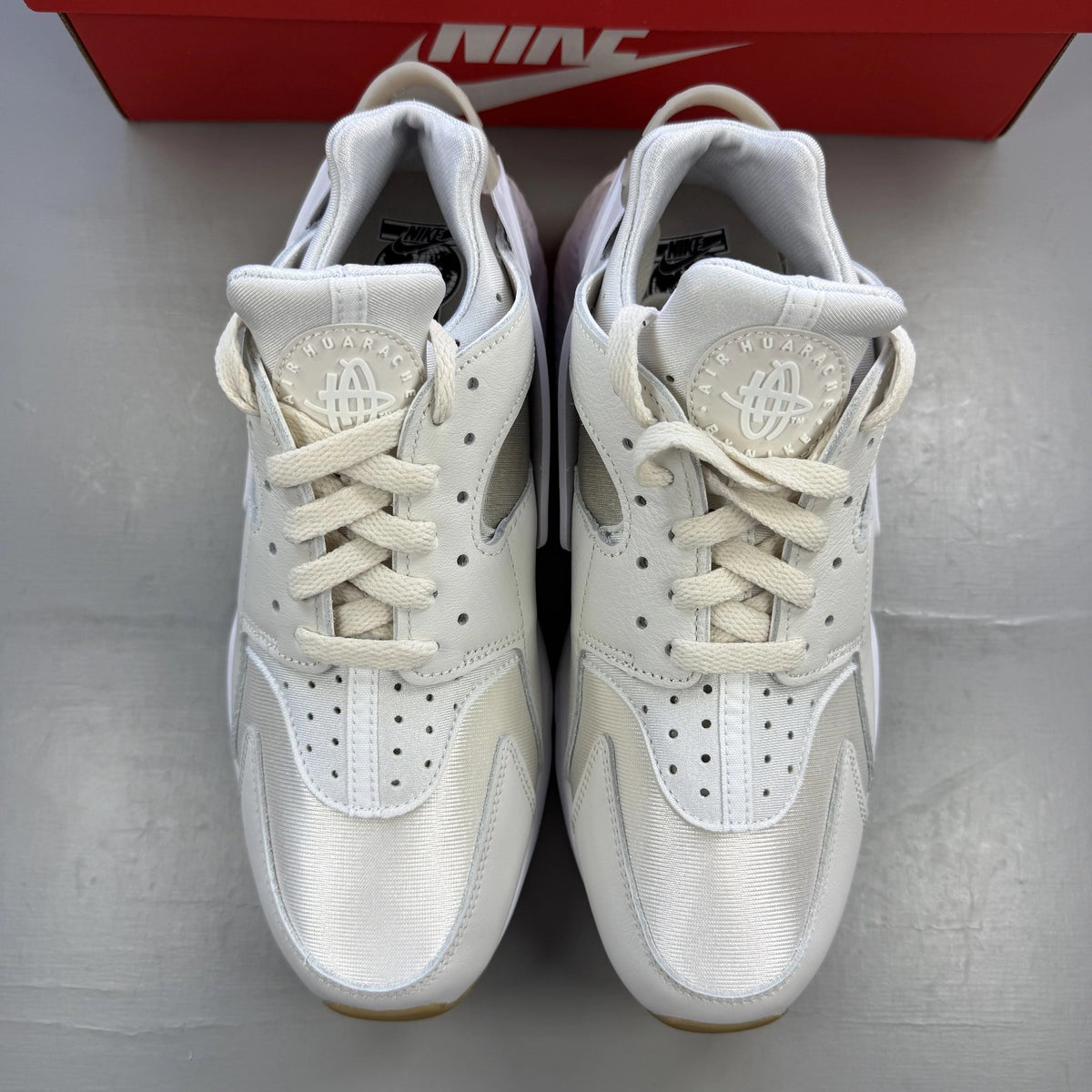 Nike white Air Huarache trainers with gum sole and logo detailing.