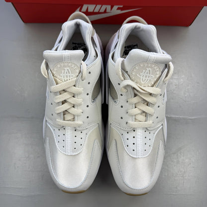 Nike white Air Huarache trainers with gum sole and logo detailing.